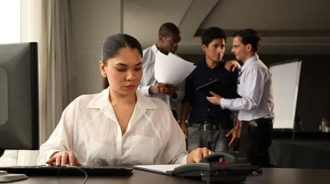 Female office staff working. Colleagues chatting and laughing in backgound. Stock Footage