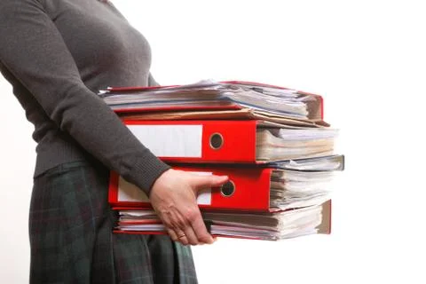 Female office worker carrying a stack of files Stock Photos