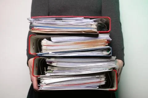 Female office worker carrying a stack of files Stock Photos