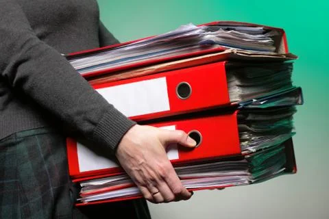 Female office worker carrying a stack of files Stock Photos