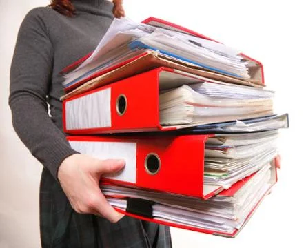 Female office worker carrying a stack of files Stock Photos