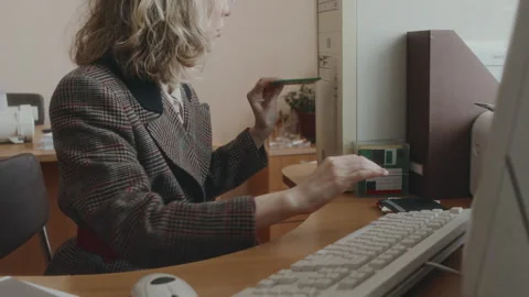 Female Office Worker Inserting Floppy Diskette into Computer in 90s Stock Footage 280263748