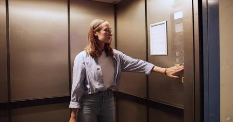 Female Office Worker Operating Elevator Panel, Going Up To Board Stock Photos