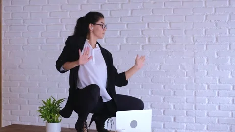 Female office worker performs spontaneous dance on desk. Energetic dance breaks Video stock 279023367