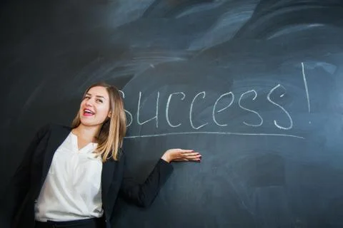 Female office worker put down text success on black board Fotos de archivo