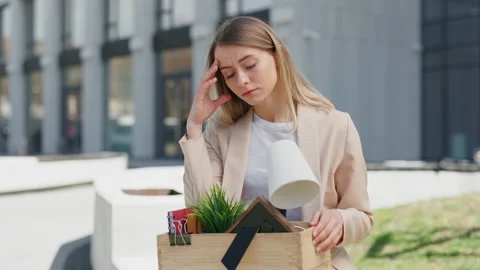 Female office worker sitting upset with box of belongings Stock Footage 196243953