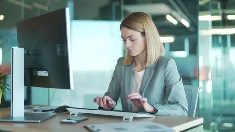 Female office worker in suit working at computer pc in front of monitor  Stock Footage 169362093