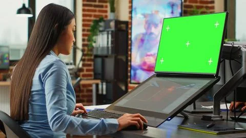 Female office worker using game developing interface and greenscreen display 스톡 사진