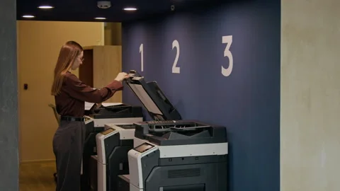 Female Office Worker Using Multifunction Printer to Copy Document in Office Stock Footage 333391876