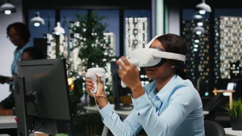 Female office worker using VR headset with artificial intelligence after hours 動画素材 318497132