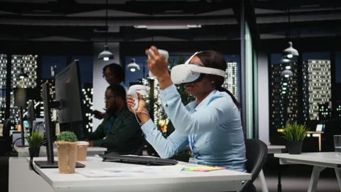 Female office worker using VR headset with artificial intelligence after hours 動画素材 318497526