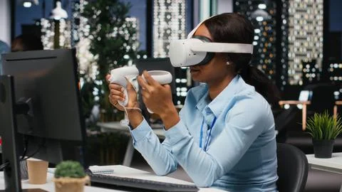 Female office worker using VR headset with artificial intelligence after hours Stock Photos