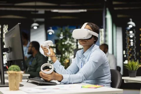 Female office worker using VR headset with artificial intelligence after hours Stock Photos