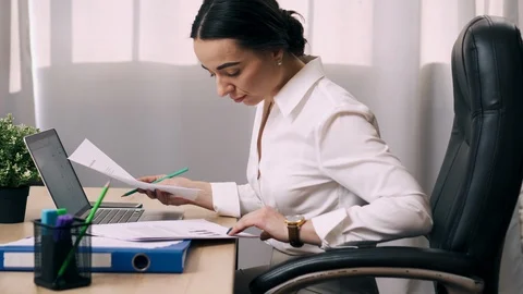 Female office worker viewing documents in workplace Stock Footage 104207046