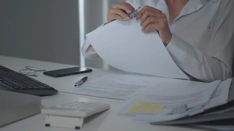 Female Office worker working on her desk hand holding business report paperwork Stock Footage 128352571