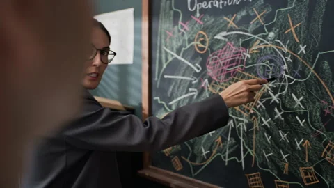 Female Officer Explaining Tactical Strategy on Blackboard to Soldier Stock Footage 343739616