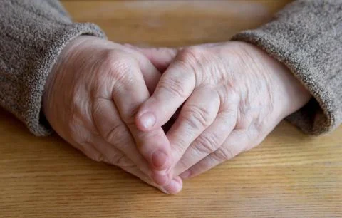 Female old hands on the table Stock Photos