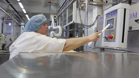 A female operator changes the settings of a conveyor belt Stock Footage 128643035