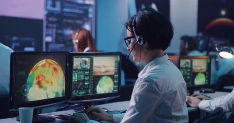 Female operator using computer to launch rocket in office Stock Footage 148226653