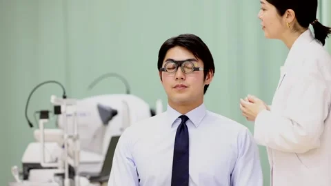 Female Ophthalmologist Adjusting Trial Frames During Male Patient Eye Test 스톡 동영상 344237907