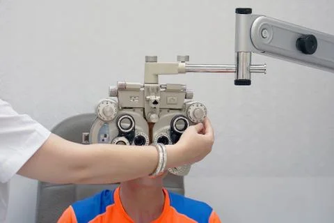 Female Optometrist Doing Sight Testing For Male Patient In Clinic Stock Photos