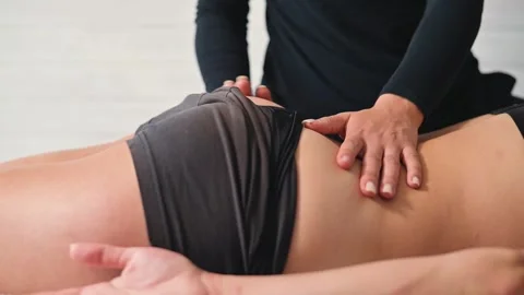 A female osteopath performs manual therapy and massage on a patient to relieve Vídeo Stock 344377553