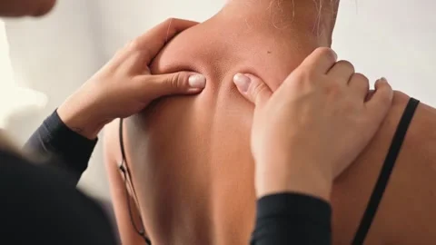 A female osteopath performs manual therapy on a female patient, focusing on the 스톡 동영상 344378499