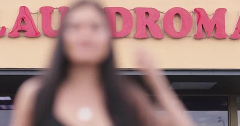 Female outside Laundrette looking to camera Stock Footage 82437520