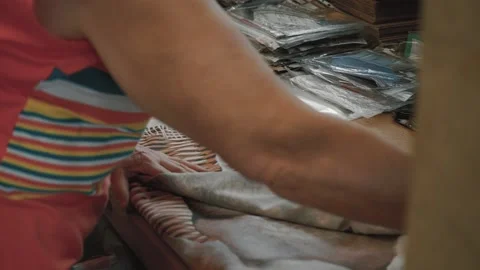 A female packer packs a set of bed linen Stock Footage 130507489