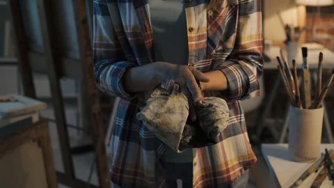 Female painter cleaning her hands with a cloth Stock Footage 90385836