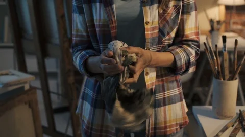 Female painter cleaning her hands with a cloth Stock Footage 90385871