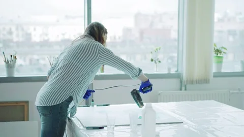Female painter creating abstract fluid painting at desk Video stock 108687193