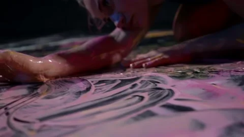 Female painter is drawing by hands and dyes on floor, contemporary art Stock Footage 168533832