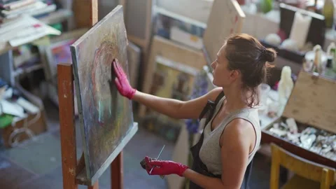 Female painter fixing artwork Video stock 142667575