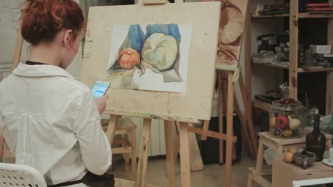 Female painter using smartphone in workshop Vidéo 71413928