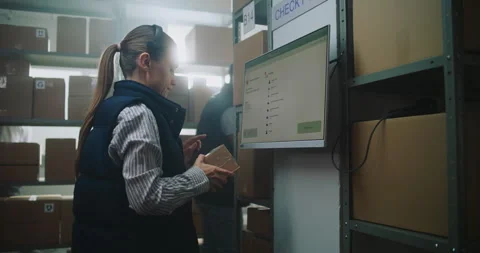 Female Parcel Processing Specialist Checks Package Delivery Information at Stock Footage 307664512