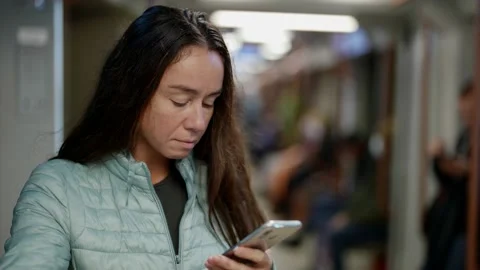 Female passenger in train of subway is using smartphone, surfing internet Vídeos de archivo 163326501