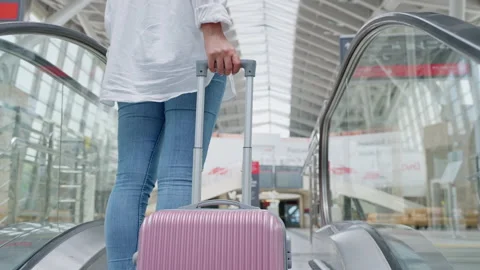 Female passenger using moving staircase for lifting on second floor of terminal Stock-Footage 232415154