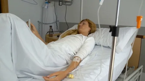 A female patient in a hospital ward with a drip Stock Footage