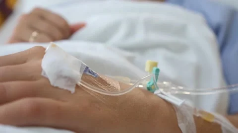 Female Patient with IV Drip Needle Lying on Bed in Hospital Stock Footage