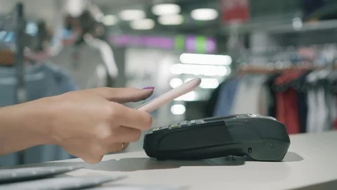 Female paying through smart phone using NFC technology. Hands close up view Stock Footage 99580271
