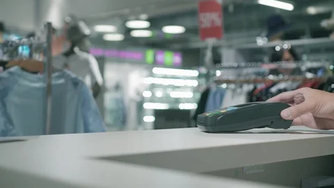 Female paying through smart phone using NFC technology. The seller gives and Stock Footage 99580953