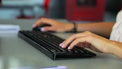 A female person using a PC keyboard and mouse Stockbeeldmateriaal 156783724