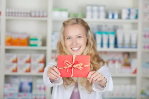 Female pharmacist with bonus coupon card gift Stock Photos