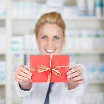 Female pharmacist holding out gift coupon Stock Photos