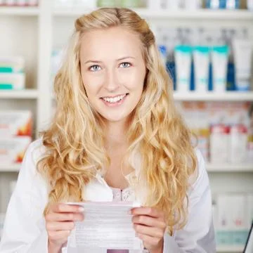 Female pharmacist holding prescription paper Stock Photos