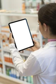 Female pharmacist looking at the screen of a digital tablet in the pharmacy Foto stock