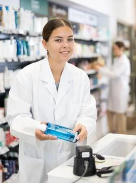 Female pharmacist scans qr code of product at checkout for sale in pharmacy Stock-Fotos