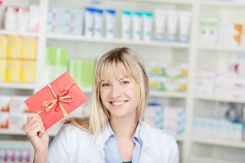 Female pharmacist showing coupon Stock Photos