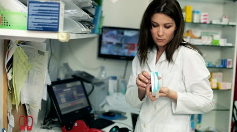 Female pharmacist working in back of store tagging medicine Stock Footage 45622423